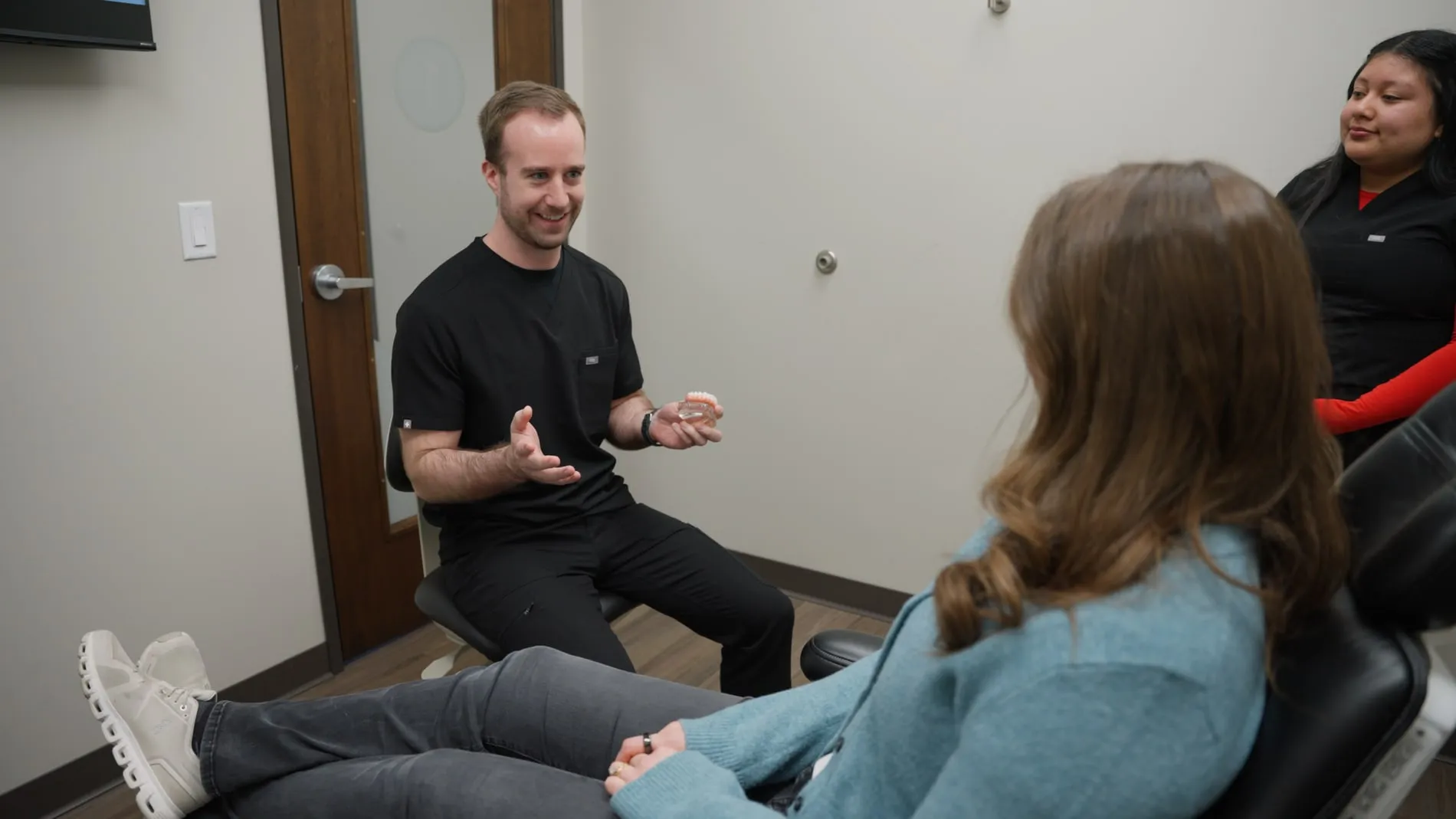 An Emergency Dental dentist explaining treatment to a patient in the chair