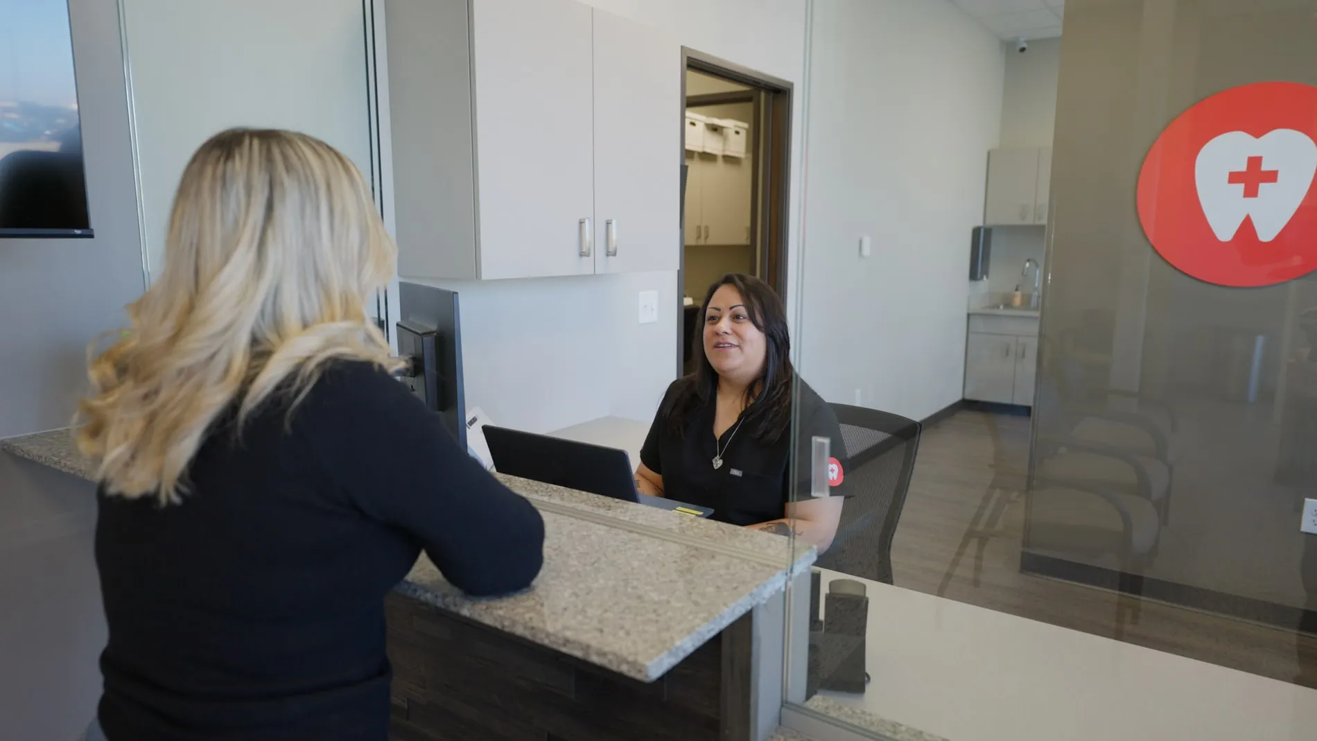 A patient being welcomed at the Emergency Dental front desk